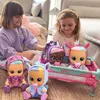 Two young girls are playing with baby dolls in a nursery-like setting. Voir les images du produit