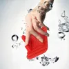 A hand is holding a red object underwater with bubbles. Produktbild-Vorschau