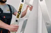 A person in overalls is holding a ladder. Podgląd zdjęcia produktu