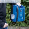 A person is holding a blue and black pressure washer outdoors, with greenery in the background. Produktbild-Vorschau