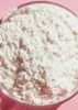 A close-up view of a bowl filled with white powder, likely an ingredient or supplement, set against a pink background. Produktbild-Vorschau