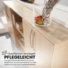 A close-up view of a light wood cabinet with silver handles, featuring a glass vase with decorative branches and fruit on top. Text overlays describe the product's features. Produktbild-Vorschau