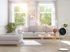 A bright, sunlit living room with a modern white fan in the foreground. Voir les images du produit