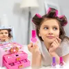 A young girl with hair rollers is playing with a toy makeup set. Produktbild-Vorschau