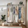 A clothing rack with clothes hanging on it, placed against a wall with decorative items and a plant. Produktbild-Vorschau