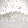A pile of loose artificial snow is shown, with some pieces falling from above. Voir les images du produit