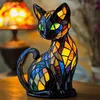 A stained glass cat lamp sits on a wooden table, with a blurred lamp in the background. Produktbild-Vorschau