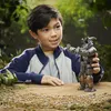 A young boy is playing with a robot toy in an outdoor setting. Anteprima dell’immagine prodotto