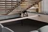 Close-up view of the underside of a bed frame, showing the wooden slats, metal mechanism, and part of the upholstered bed frame. Náhled obrázku produktu