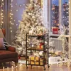 A festive Christmas scene with a white Christmas tree, decorated with lights and ornaments, and a serving cart filled with gifts and wine glasses. Produktbild-Vorschau