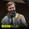 A man is holding a car oil filter in front of a garage door. Produktbild-Vorschau