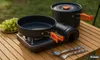 Camping cookware set on a wooden table outdoors with grapes in the background. Náhled obrázku produktu