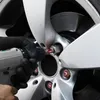 A person wearing a black glove is using a tool to tighten a lug nut on a car wheel. Produktbild-Vorschau