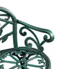 A close-up view of a green metal garden bench with ornate scrollwork and a rose pattern. Podgląd zdjęcia produktu