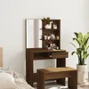 A vanity table with a mirror and shelves filled with various cosmetic products, placed in a room with a bed and a plant. Voir les images du produit