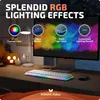 A desk setup with a computer monitor displaying colorful RGB lighting effects, a keyboard with RGB lighting, a desk lamp, and decorative pumpkins and candles. Produktbild-Vorschau
