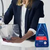 A person is holding a clear plastic tank under a faucet, and a bottle of Bissell Spot & Stain Pro Oxy cleaner is next to it. Voir les images du produit