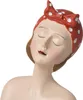 A close-up of a decorative figurine of a woman's head and shoulders, wearing a red and white polka dot headscarf. Voir les images du produit
