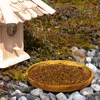 A bird feeder with seeds and a bird in a natural outdoor setting. Produktbild-Vorschau