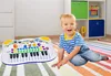 A young boy is sitting on a colorful rug next to a toy keyboard in a room with shelves in the background. Anteprima dell’immagine prodotto