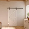 Weiße Holzschiebetür mit Scheunentor Dekor und schwarzem Beschlag in modernem, hellem Wohnraum  Produktbild-Vorschau