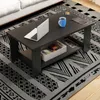 A dark gray coffee table with a laptop, a blue mug, and magazines on it, placed on a patterned rug in a living room setting. Produktbild-Vorschau