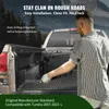 A man is placing a black storage box into the bed of a pickup truck. The background shows a mountainous landscape. Náhled obrázku produktu