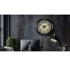 A modern office desk with a computer monitor, a desk lamp, and a decorative plant, with a large wall clock in the background. Produktbild-Vorschau