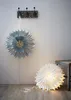 Two paper star lanterns, one hanging on a wall and one on the floor, with a coat rack above. Podgląd zdjęcia produktu