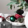 Christmas ornaments and eucalyptus branches arranged on a table. Voir les images du produit