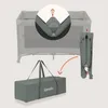 An image showing a travel crib being folded and placed into its carrying bag, with a close-up inset of a folding mechanism. Voir les images du produit