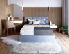 A bedroom scene featuring a bed with a mattress and bedding, a vanity area with a chair, and decorative elements. Produktbild-Vorschau