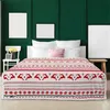 A bedroom scene with a bed covered by a festive blanket. Produktbild-Vorschau