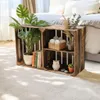 Wooden crates used as a bedside table next to a bed, decorated with plants and books. Anteprima dell’immagine prodotto