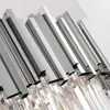 A close-up view of a modern chandelier with metallic elements and crystal-like pendants. Produktbild-Vorschau