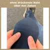 A close-up of a person's hands holding a blue sock, with legs and shoes in the background. Produktbild-Vorschau