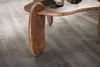 A close-up view of a wooden coffee table leg resting on a gray carpet. Voir les images du produit