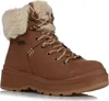A single brown boot with cream-colored fur trim and brown and white laces is shown against a white background. Produktbild-Vorschau