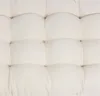 A close-up view of a beige tufted cushion. Produktbild-Vorschau