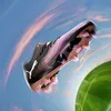 A Puma Future 8 Ultimate FG football boot is shown in mid-air against a sky with pink clouds and a blurred green football field with a goal in the background. Produktbild-Vorschau
