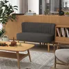 A dark gray loveseat is placed in a living room setting with a wooden coffee table and a bookshelf. Produktbild-Vorschau