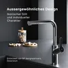 A modern kitchen faucet is shown on a dark countertop, with a glass jar of nuts and a small wooden dish of nuts in the background. Produktbild-Vorschau