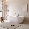 A modern, minimalist bathroom with a freestanding bathtub, a wooden stool, and a rug. Náhled obrázku produktu