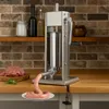 A sausage stuffer is shown in operation on a kitchen counter, with a pile of ground meat and a finished sausage coil. Náhled obrázku produktu