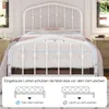A white metal bed frame with a mattress, shown in a bedroom setting with windows and furniture in the background. An overlay highlights the mattress support system. Produktbild-Vorschau