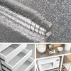 A collage showing a roll of textured silver material and examples of its use in drawers and on shelves. Produktbild-Vorschau