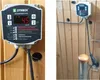 A Dymbox temperature regulator is mounted on a wooden wall, connected to cables and a heating element. Náhled obrázku produktu
