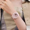 A close-up shot of a person's arm wearing a pink watch. Produktbild-Vorschau