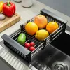 A kitchen sink with an adjustable dish rack filled with fruits and vegetables. Produktbild-Vorschau
