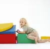 A child playing with colorful blocks on a white background. Produktbild-Vorschau